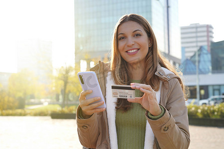 银行账户摄影照片_在智能手机上输入信用卡号码的美丽自信女孩的肖像可以在线购买或查看银行账户