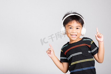 5-6 岁的小可爱小男孩用无线耳机听音乐