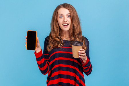 女人拿着咖啡去，展示智能手机与空白屏幕的广告。
