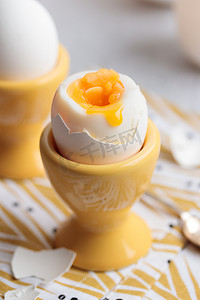 双十一海报黄色摄影照片_黄色蛋杯中的半熟鸡蛋