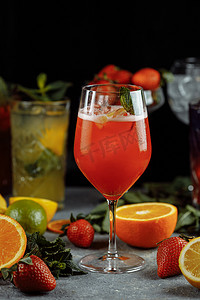 清凉饮料摄影照片_夏季色彩缤纷的清凉饮料，冷草莓柠檬汁，玻璃杯里加冰块，饰有切片新鲜柠檬