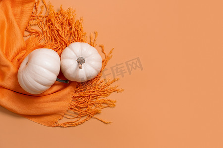 感恩节二摄影照片_秋季平躺组合物，橙色围巾顶视图上有白色南瓜，有复制空间