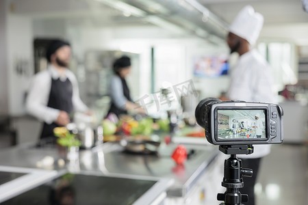 相机拍摄餐厅厨房厨师为烹饪学校课程烹饪美食的选择性焦点。