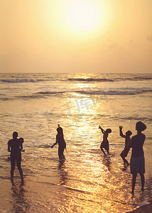 斯里兰卡卡卢特勒-2017 年 4 月 15 日：人们的轮廓，大部分是在金色夕阳的夕阳下在海边沙滩上玩耍的孩子。