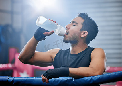 适合、活跃且健康的拳击手在日常锻炼、训练或拳击场运动中休息时喝水并保持水分。