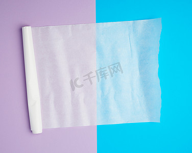 蓝紫色背景上展开的白色羊皮纸烘焙纸