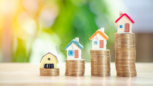 金币上的房屋或房屋在木桌上 4 行。贷款、财产阶梯、金融、抵押、房地产投资、税收、住房贷款和奖金的概念。