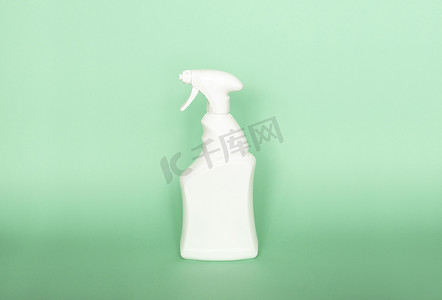 用于在绿色背景下隔离的液体清洁产品的白色塑料喷雾瓶。