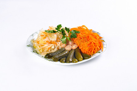 白色背景中盘子上的腌菜、黄瓜、胡萝卜、大蒜、卷心菜