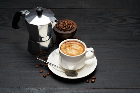 深色木质背景中的一杯浓咖啡和摩卡咖啡机