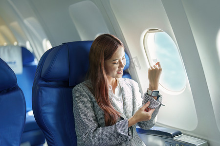 一位年轻的亚洲女商人在乘坐飞机时微笑的肖像