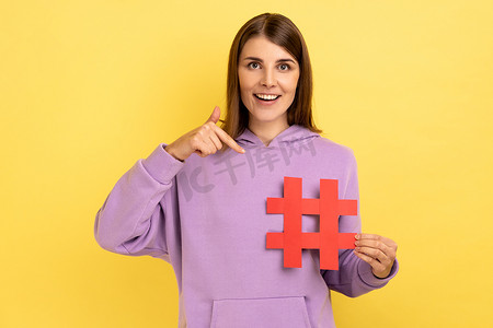 快乐的女人指着红色标签符号，使重要话题在互联网上流行设置趋势
