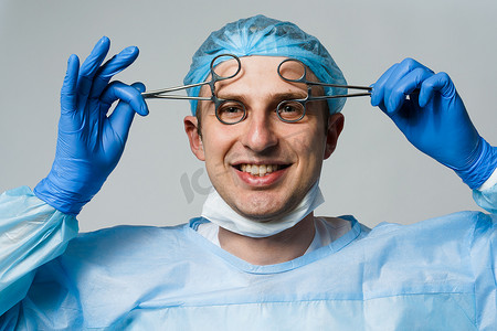 疯狂工作摄影照片_带着疯狂情绪的古怪微笑的医生外科医生。