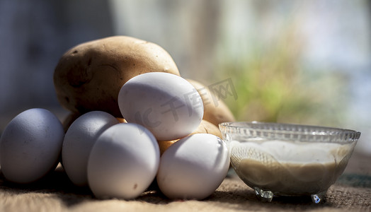 土豆和蛋清面膜，用生土豆和鸡蛋以及在玻璃碗中制成的面膜，在棕色表面上实现自然发光的皮肤。