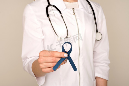 结直肠摄影照片_医生手拿着蓝丝带、糖尿病和结直肠癌意识