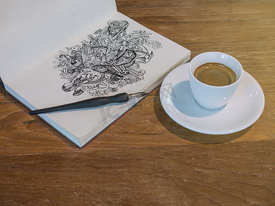 线条美学摄影照片_用一杯咖啡在纸上用黑色墨水画涂鸦线条艺术