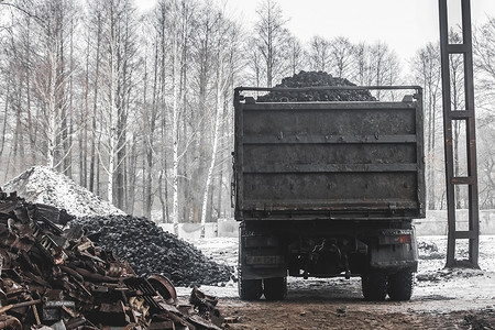 垃圾填埋场或工业区的自卸车从车身上卸下一堆炼焦煤
