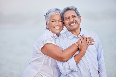 在退休假期、假期或休息时，高级爱情、拥抱和肖像夫妇在海滩上信任拥抱、安全和安全。