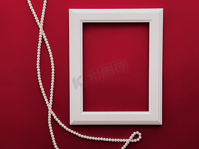 白色垂直艺术框架和红色背景珍珠首饰，作为平面设计、艺术品印刷品或相册