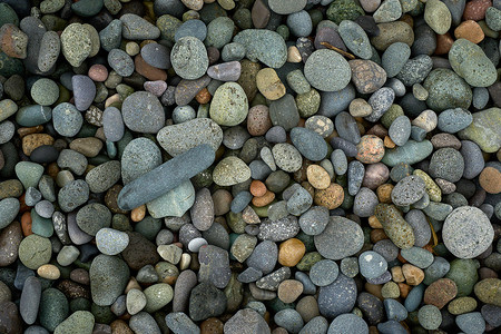 海边随机大小的石头和彩色光滑卵石的抽象背景纹理