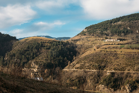冬季乡村房屋摄影照片_美丽的山区乡村景观，很少的农舍，冬季阳光明媚的蓝天白云，西班牙的乡村风光