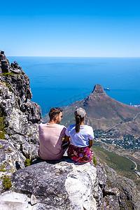 一对男女在桌山山顶，从南非开普敦的桌山眺望，从桌山开普敦眺望海洋和狮头
