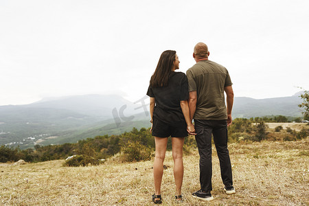 一对夫妇站着看雾山的背影