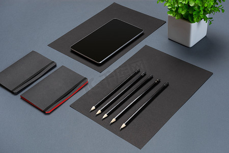 现代模拟平躺的笔记本和文具灰色背景。