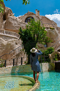 穿裙子的女人摄影照片_洞穴屋穿裙子的女人，卡帕多西亚山区的女人无边泳池洞穴屋酒店