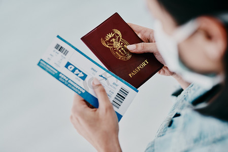 移民符文摄影照片_旅行、新冠病毒和旅游签证或护照，同时在机场持有带口罩的机票进行移民。