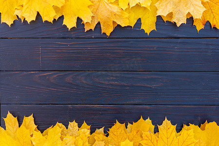 橙色复古边框摄影照片_秋叶框架在木质背景顶视图秋季边框黄色和橙色叶子复古木桌复制文本空间。