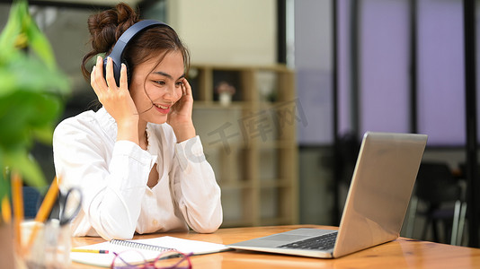 漂亮的年轻女子，在网上聊天，在笔记本电脑上在线学习期间听讲座。