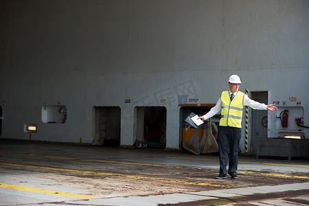 物流经理摄影照片_物流工人、经理或工程师，在船厂或货运码头工作。