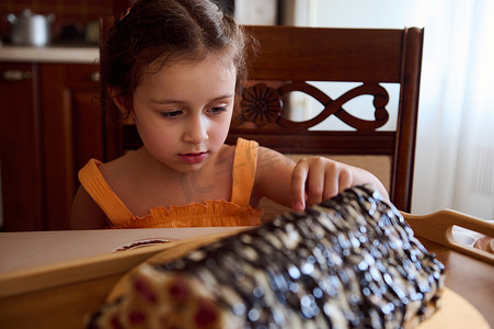 可爱的小女孩坐在餐桌上，桌上摆着自制的樱桃派 — 家庭厨房内部的修道院小屋