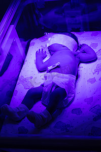 紫外线灯摄影照片_紫外线灯下的新生婴儿。