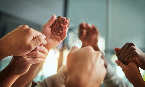 不同的人手牵手进行团队合作、成功和支持，同时在办公室中表现出团结、信任和团结。