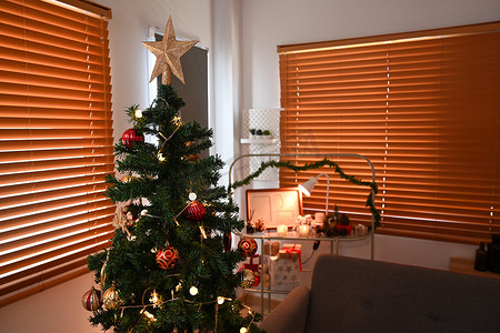 舒适的客厅点亮了柔和的灯光和蜡烛，准备庆祝新年和圣诞节节日