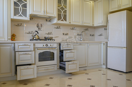 一室公寓内经典的白色和米色厨房家具