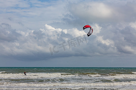 高难度动作摄影照片_专业的风筝手在美丽的背景下完成了高难度的动作。