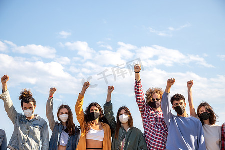 举起拳头的多种族抗议者戴着口罩。