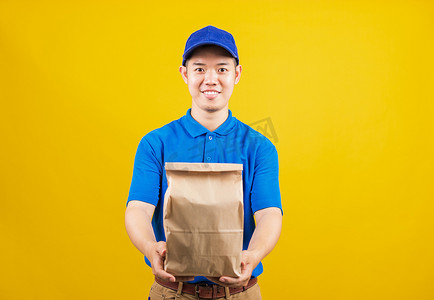 杂货食品摄影照片_送货服务男子微笑着拿着外卖袋杂货食品的纸容器