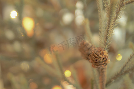 金色雪花图案摄影照片_金色圣诞节背景的去焦点灯与装饰树。