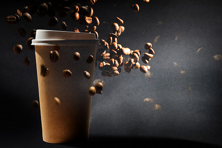 一张纸咖啡杯的照片，背景是阿拉比卡咖啡豆和罗布斯塔咖啡豆的混合物。
