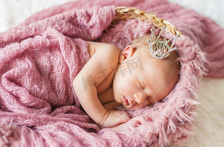 戴着女孩皇冠的新生婴儿。
