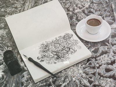 用一杯咖啡在纸上用黑色墨水画涂鸦线条艺术