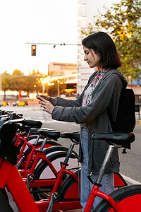 女孩用电话在公共停车场骑自行车