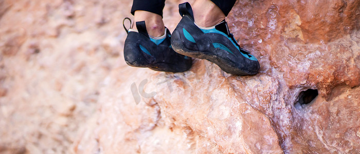 在岩石特写镜头上穿着登山鞋的脚。