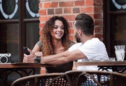 坐在咖啡馆露台上的一对年轻夫妇的画像