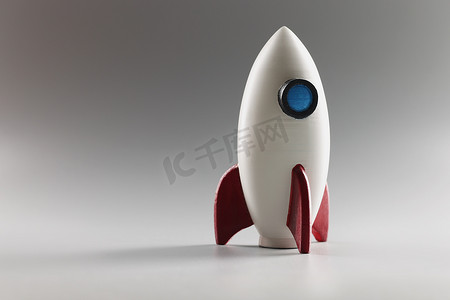 火箭启动摄影照片_微型火箭玩具站在地面上，火箭飞船作为商业项目和创业的象征