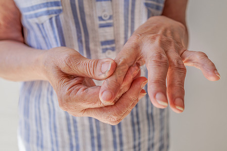 特写，一位老妇人给自己做手部按摩，关节炎，关节病